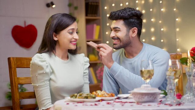 Happy Girl Taking Bite Of Chocolate From Boyfriend During Valentines Day Dating - Concept Of Wedding Anniversary, Romantic Moment And Togetherness