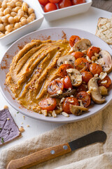 Hummus de garbanzo con salteado de tomates y champiñones acompañado de tostadas de diferentes sabores
