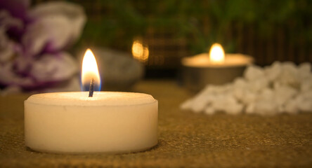 Candles lit at night and stones with decorative objects. Spa decoration.