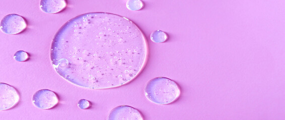 round transparent drop of clear gel serum on pink background