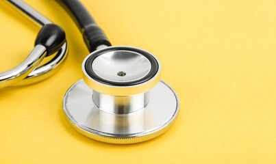 Stethoscope on a yellow background with space for text.