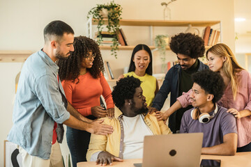 Multicultural businesspeople working in an office lobby. Group of happy businesspeople smiling while sitting together in a co-working space. Young entrepreneurs collaborating on a new project.