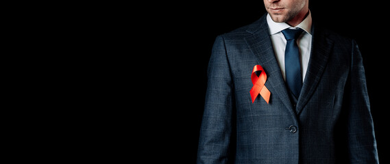 Hiv aids. Red ribbon in hiv world day isolated on dark background. Man holding awareness aids and cancer symbol. Health, Medical sign. copy space.