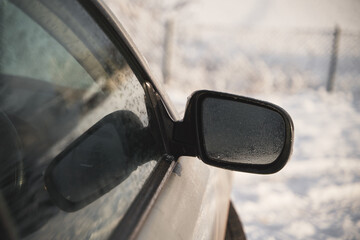 Rearview mirrors are covered with condensation. Raindrops and water on the side view mirror of the car
