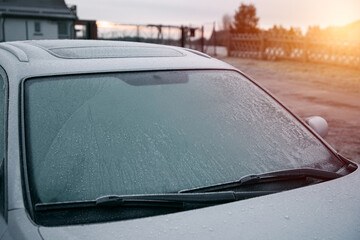 frozen windshield wiper. concept of dangerous driving during the winter season.