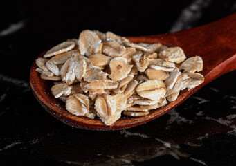 Grains of oats in a beautiful wooden spoon. Close-up. macro shot