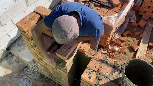 The builder performs bricklaying at the construction site. 4k video footage