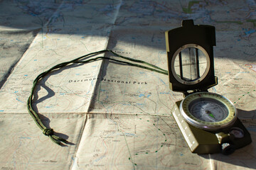Dartmoor national park map with an open compass placed on it. Used for navigating and orienteering. Selective focus on the word National. Used in the Ten Tors walk and outdoor adventures. Copy space. 