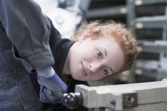 Young female engineer operating lever in an industrial plant, Freiburg im Breisgau, Baden-Württemberg, Germany