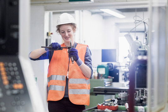 Young female engineer repairing machine part in an industrial plant, Freiburg im Breisgau, Baden-W&uuml;rttemberg, Germany