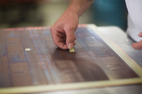 Close-up of human hand examining circuit board in industry, Hanover, Lower Saxony, Germany