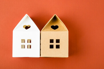 The White and Brown paper house origami on red background with empty space for your text or message.