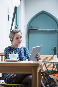 Young woman holding digital tablet at coffee shop