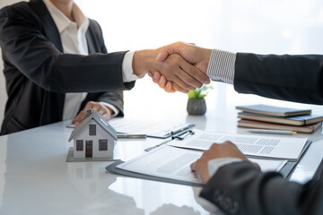 Asian businessmen and investors join hands after signing a contract to invest in a real estate...