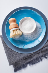 eco-friendly dishwashing brushes with organic bristles and wooden handle next to dishwashing detergent on the kitchen table. The concept of minimum consumption,