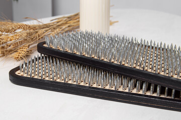 Wooden sadhu boards on white background. Acupuncture. Sharp nails. Soft focus
