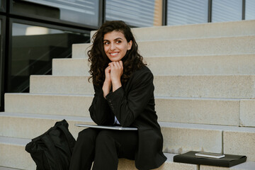 Young businesswoman using laptop while sitting on stairs outdoors