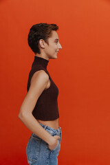 Young beautiful short-haired smiling woman with hands in pockets