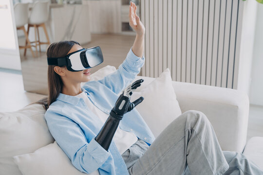 European woman is getting used to modern bionic prosthesis using vr headset. Electronic technology. - Powered by Adobe