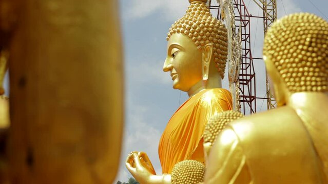 The large Golden buddha statue in sunrise light and clouds. Beliefs and faith of people in religion. Buddhism concept.