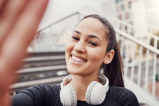 Woman, face and selfie with headphones and fitness in city, happy in Brazil, smile in portrait and exercise outdoor. Runner, cardio and happiness in picture, health and wellness with active lifestyle