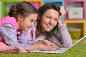 Obraz premium Mother with her little daughter using laptop