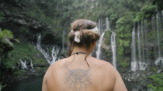 A Girl is contemplating a huge waterfall