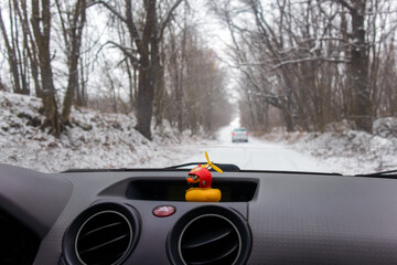Rubber duck in the car.Traveling in winter.Dashboard of the auto. Emergency button in the...