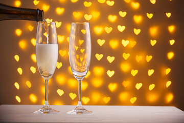 beautiful glasses of champagne on a blurred background of hearts