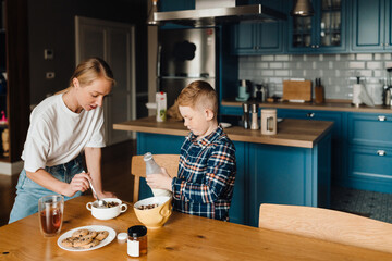 Mother and son making breakfast together in kitchen
