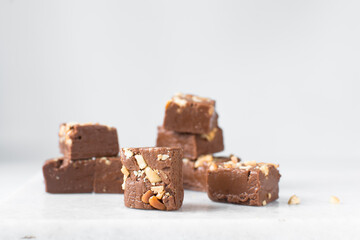 chocolate fudge with nuts on a marble tray, chocolate fudge cut into pieces, fudge candy on a marble tray