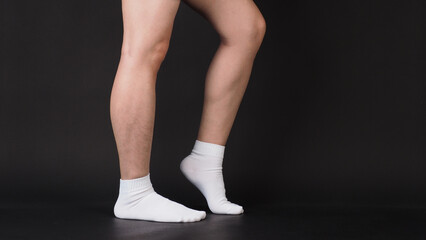 Asian Male legs wear white sock is isolated on black background