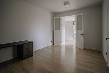 Classical empty room interior. The rooms have wooden floors and gray walls ,decorate with white moulding,there are white window looking out to the nature view.