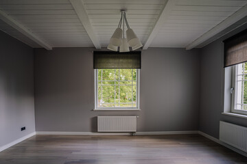 Classical empty room interior. The rooms have wooden floors and gray walls ,decorate with white moulding,there are white window looking out to the nature view.