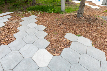 Decorating a curb or the edge of a pedestrian zone with tree bark. The uneven edge of a hexagonal...