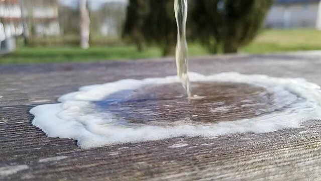 beer spilling on wood in slow motion