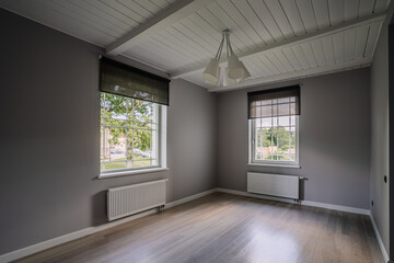 Classical empty room interior. The rooms have wooden floors and gray walls ,decorate with white moulding,there are white window looking out to the nature view.