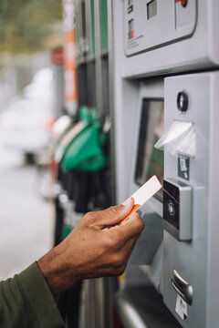 Man holding credit card while doing payment at fuel station