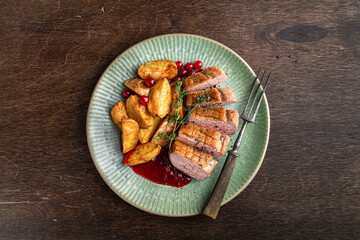 Duck breast steak with potatoes and berry sauce