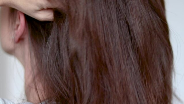smiling millennial massaging scalp with hand fingers for hair growth stimulation blood circulation half face back or front view.healthy home care slow motion 