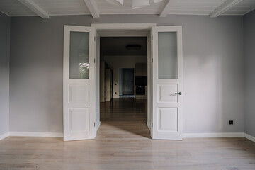Classical empty room interior. The rooms have wooden floors and gray walls ,decorate with white moulding,there are white window looking out to the nature view.