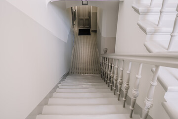 Close up on a railing leading down a grand winding staircase.