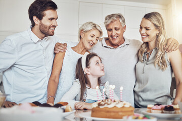 Birthday party, cake and big family with girl in celebration of special event in house. Love, food and kid with happy father, mother and grandparents celebrating, talking and bonding in home kitchen.