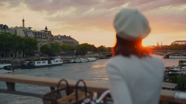Attractive girl with a bicycle looking at the sunset in Paris