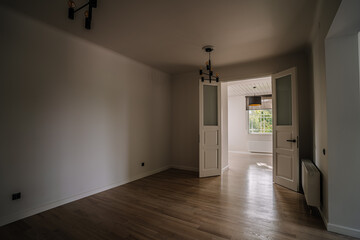 Classical empty room interior. The rooms have wooden floors and gray walls ,decorate with white moulding,there are white window looking out to the nature view.