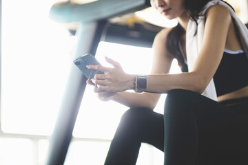 Fototapeta na wymiar Asia woman active smartphone in gym exercising