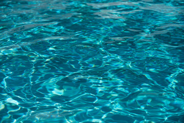 Water background, ripple waves. Blue swiming pool pattern. Sea surface. Water in swimming pool with sun reflection. Banner with copy space.