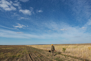 Fototapeta premium Mature man hunter with gun while walking on field.