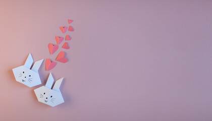 Flatlay with happy Easter bunnies made of DIY paper and pink hearts. The concept of a holiday, spring