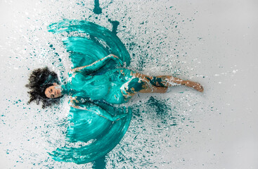 sexy naked woman in green, turquoise color painted, lies decorative, elegant on the Studio floor....
